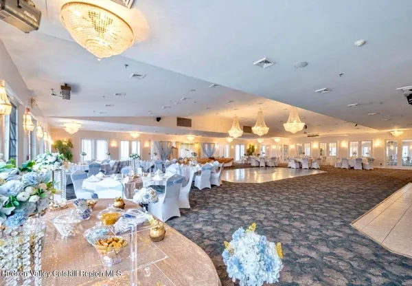 a dining room with lots of furniture and a chandelier