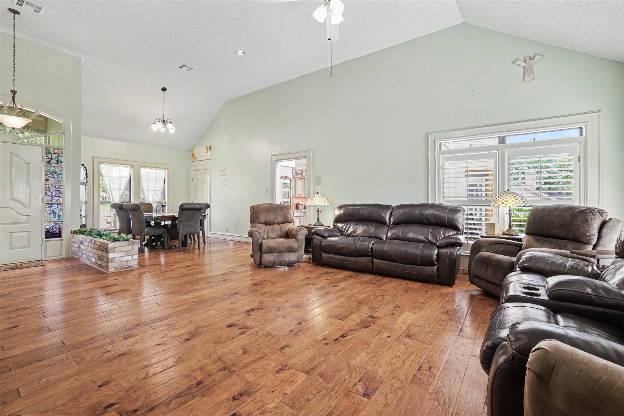 110 South Ridge Circle Georgetown, TX 78628 - Photo 6 of 37 Spacious living area featuring wood-finish flooring, vaulted ceilings, and large windows with plantation shutters