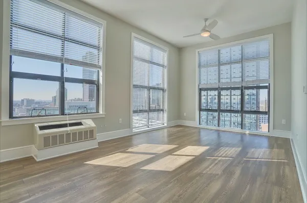 a large white kitchen with granite countertop a stove and a large window