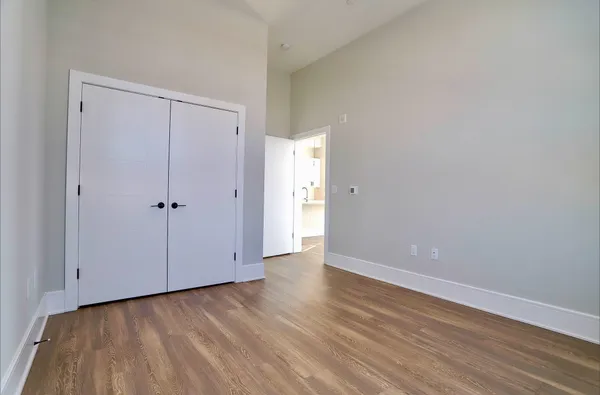 a view of an empty room with closet and a window