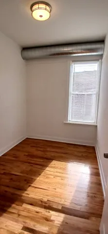 a view of a room with wooden floor and a window