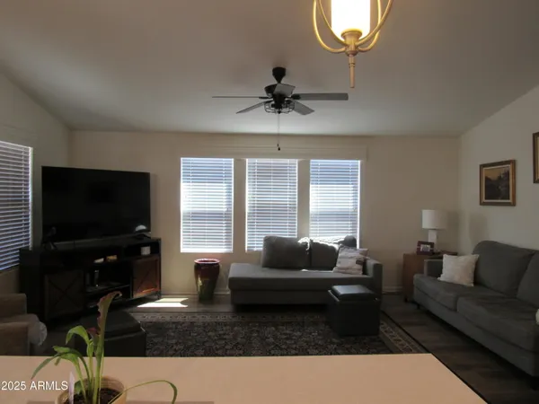 a living room with furniture a flat screen tv and a large window
