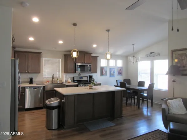 a kitchen with cabinets a sink appliances and chairs