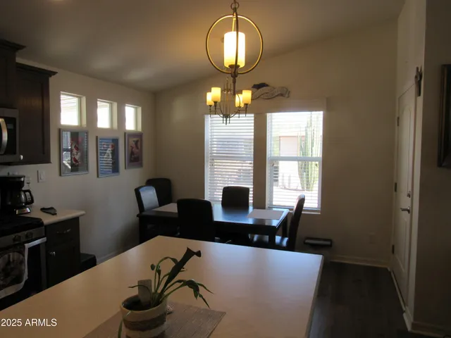 a very nice looking dining room with furniture a chandelier and window
