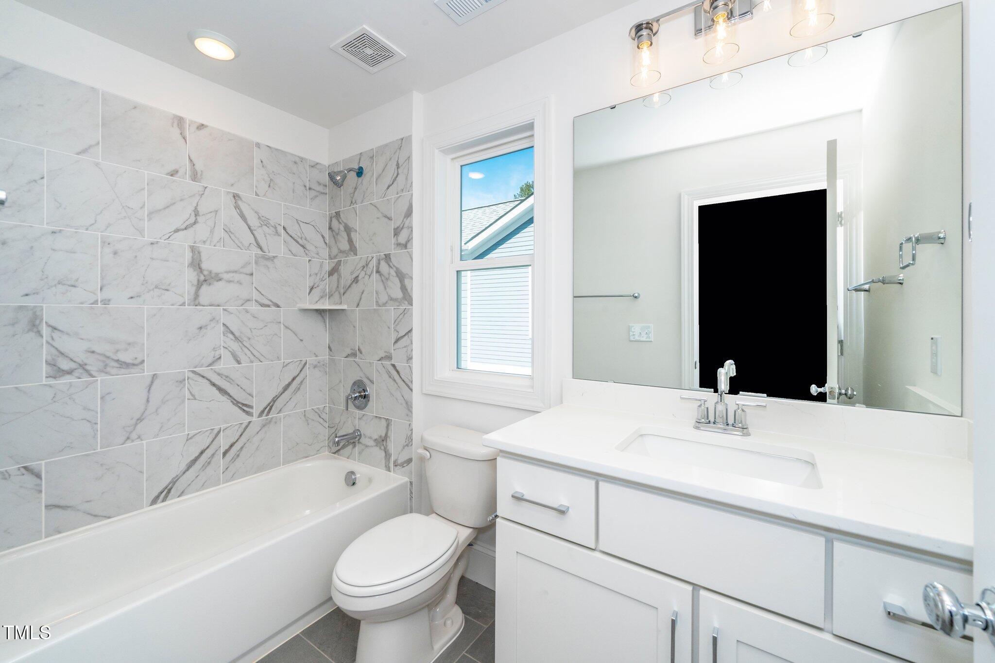 1215 Chaney Road Raleigh, NC 27606 - Photo 23 of 29 a bathroom with a sink a toilet and a bathtub