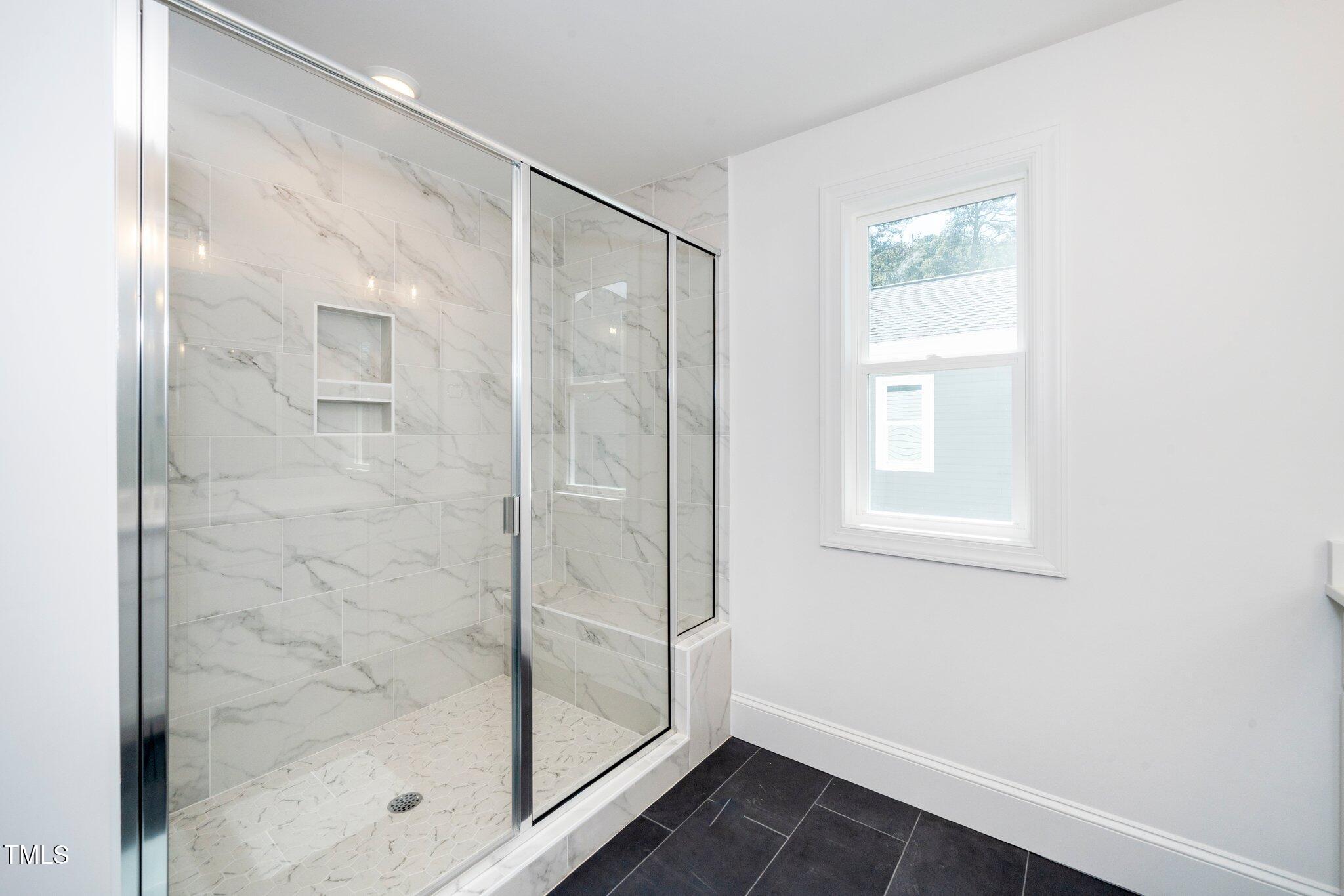1215 Chaney Road Raleigh, NC 27606 - Photo 27 of 29 a bathroom with a glass shower door