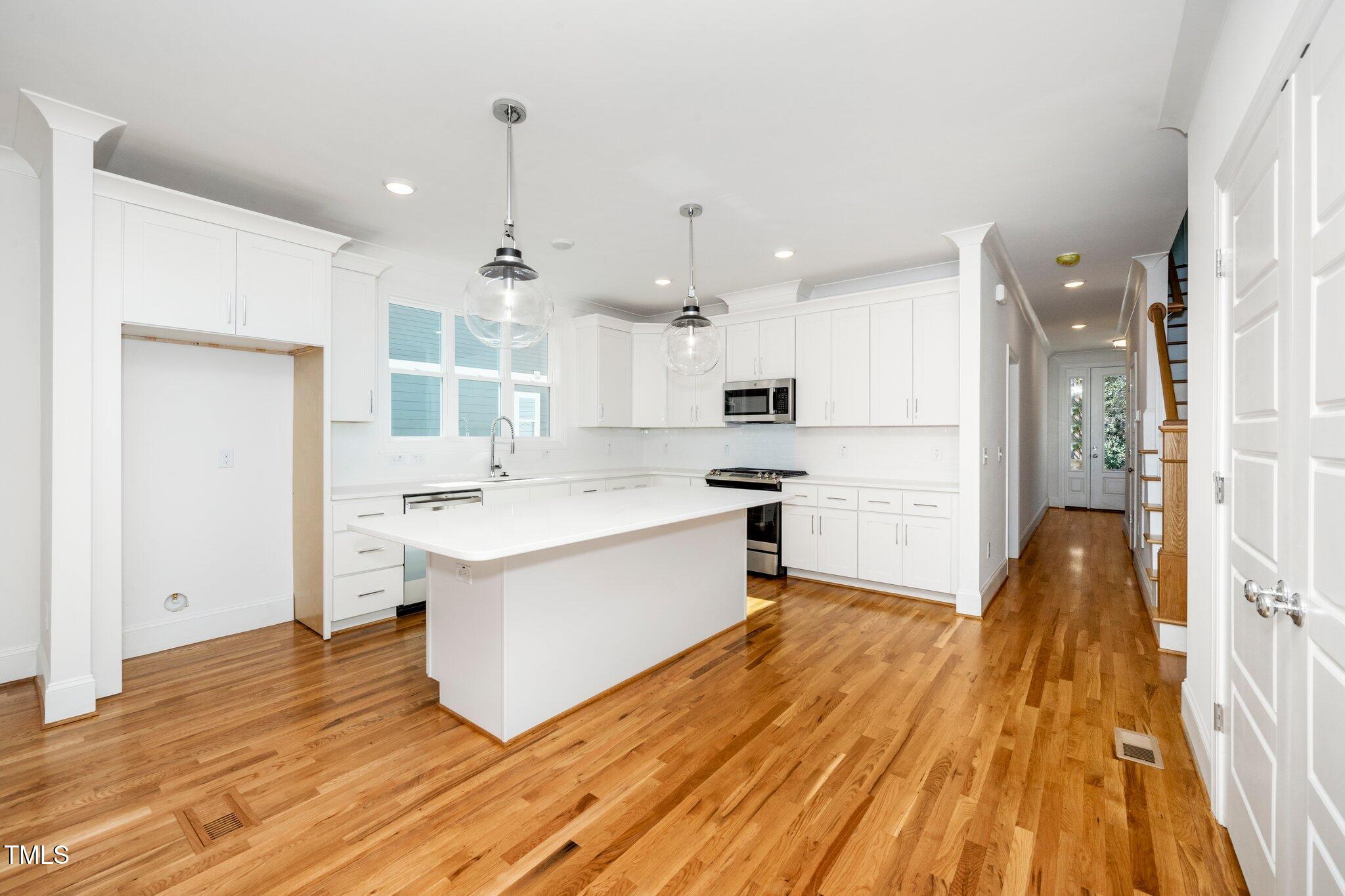 1215 Chaney Road Raleigh, NC 27606 - Photo 10 of 29 a kitchen with a sink appliances wooden floor and a window