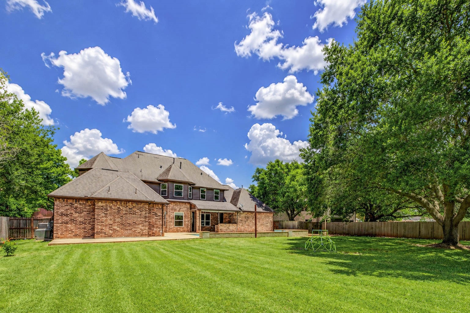 5327 Whitmore Fulshear, TX 77441 - Photo 42 of 50 This expansive backyard perspective highlights the impressive size of the nearly half-acre homesite and the privacy provided by mature landscaping. With abundant lawn space and established trees, this backyard offers endless possibilities for outdoor activities and entertaining.