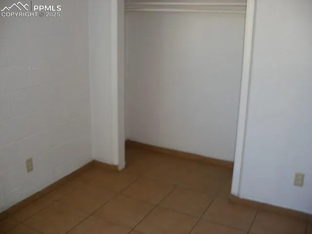 an empty room with wooden floor and mirror