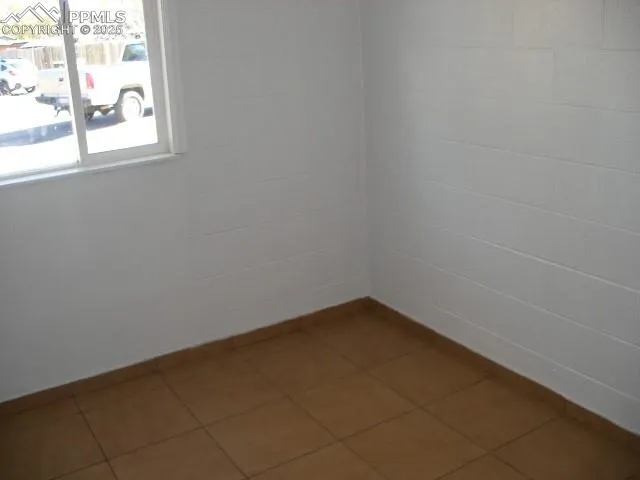 a view of a small space with wooden floor and a window