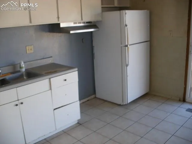 a kitchen with a refrigerator and cabinets