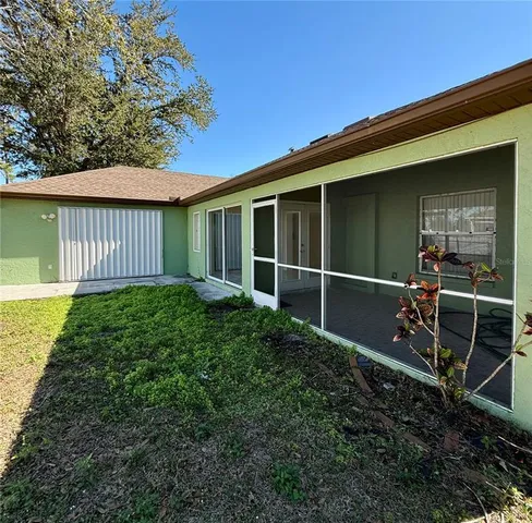 a view of a backyard with chair and floor to ceiling window