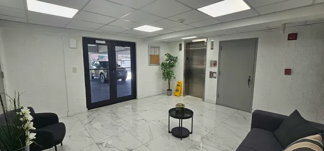 a living room with furniture and a glass door shower