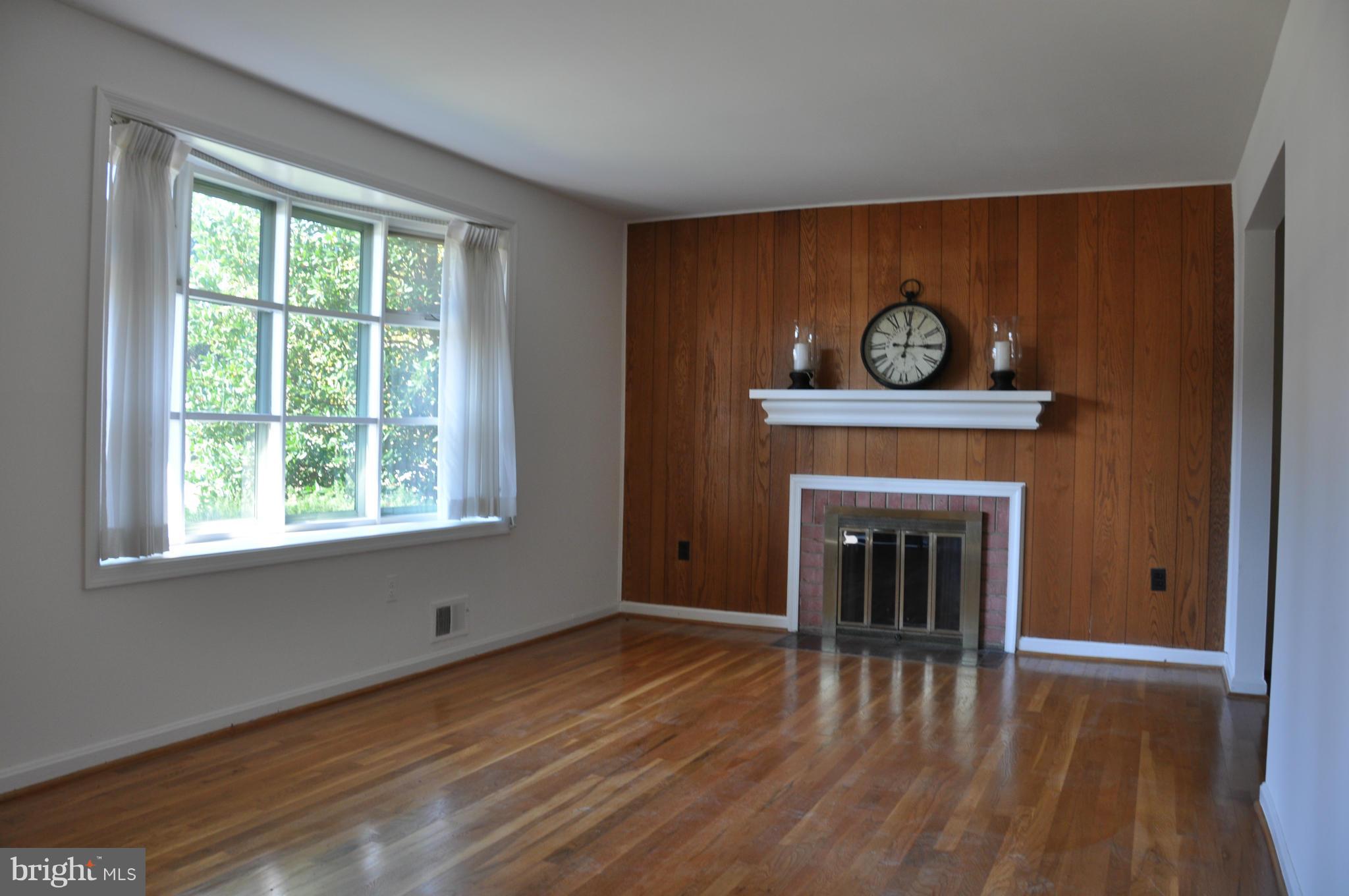 5417 Rolling Road Springfield, VA 22151 - Photo 2 of 20 a view of an empty room with wooden floor and a window