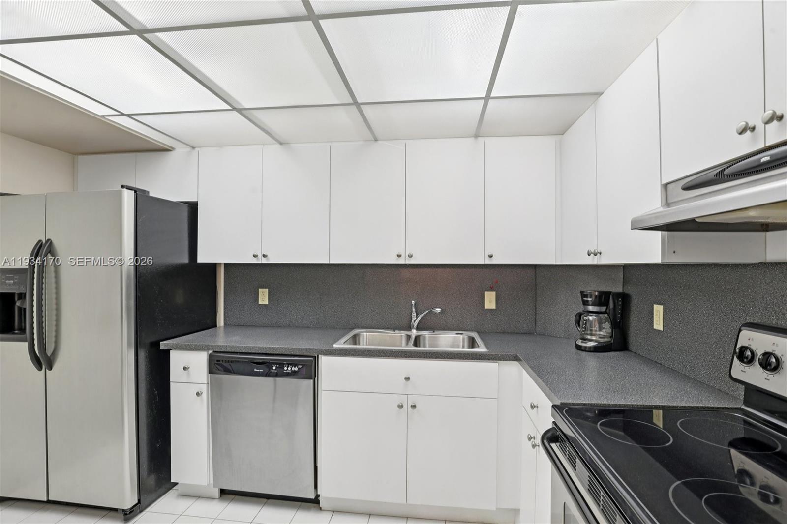 4350 Hillcrest Drive, Unit 702 Hollywood, FL 33021 - Photo 10 of 29 a kitchen with stainless steel appliances a refrigerator sink and cabinets