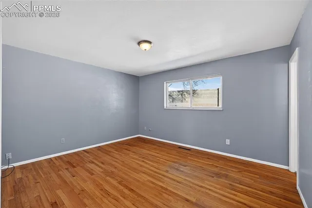 a view of an empty room with wooden floor