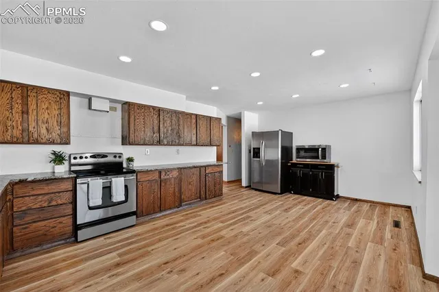 a kitchen with stainless steel appliances wooden floor sink and wooden cabinets