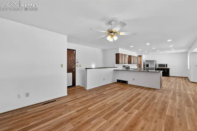 a view of a kitchen with kitchen island stainless steel appliances refrigerator sink and microwave