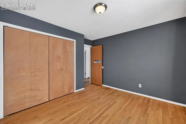 an empty room with wooden floor and sliding door