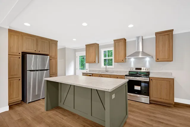 a kitchen with stainless steel appliances granite countertop a stove a refrigerator and a sink