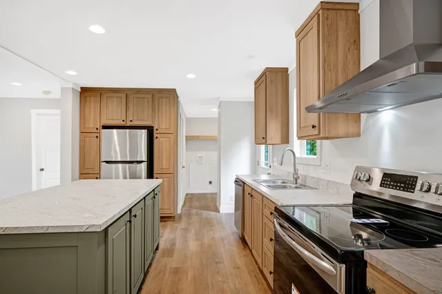 a kitchen that has a sink a stove and a refrigerator