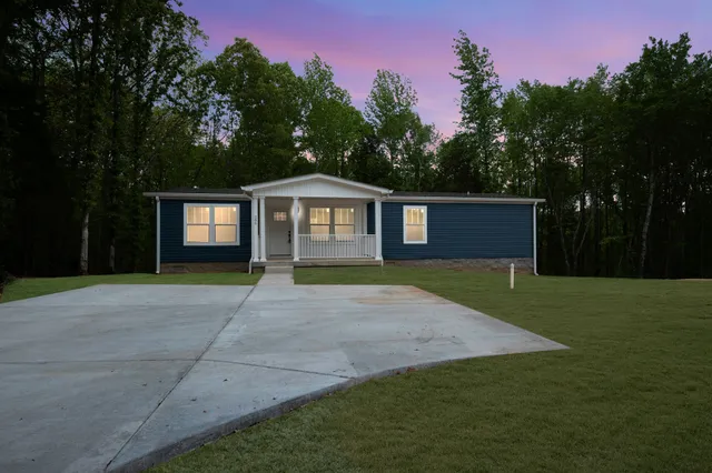 a front view of a house with a garden and yard