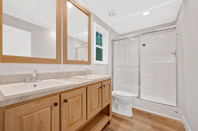 a bathroom with a double vanity sink toilet and shower