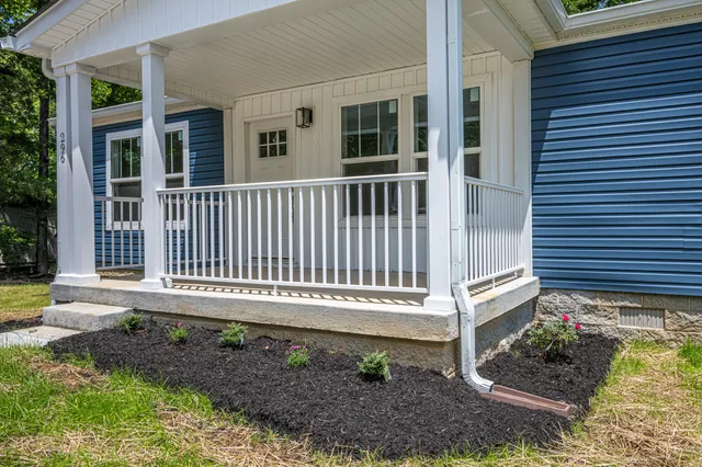 a view of a house with a small yard and wooden floor and fence