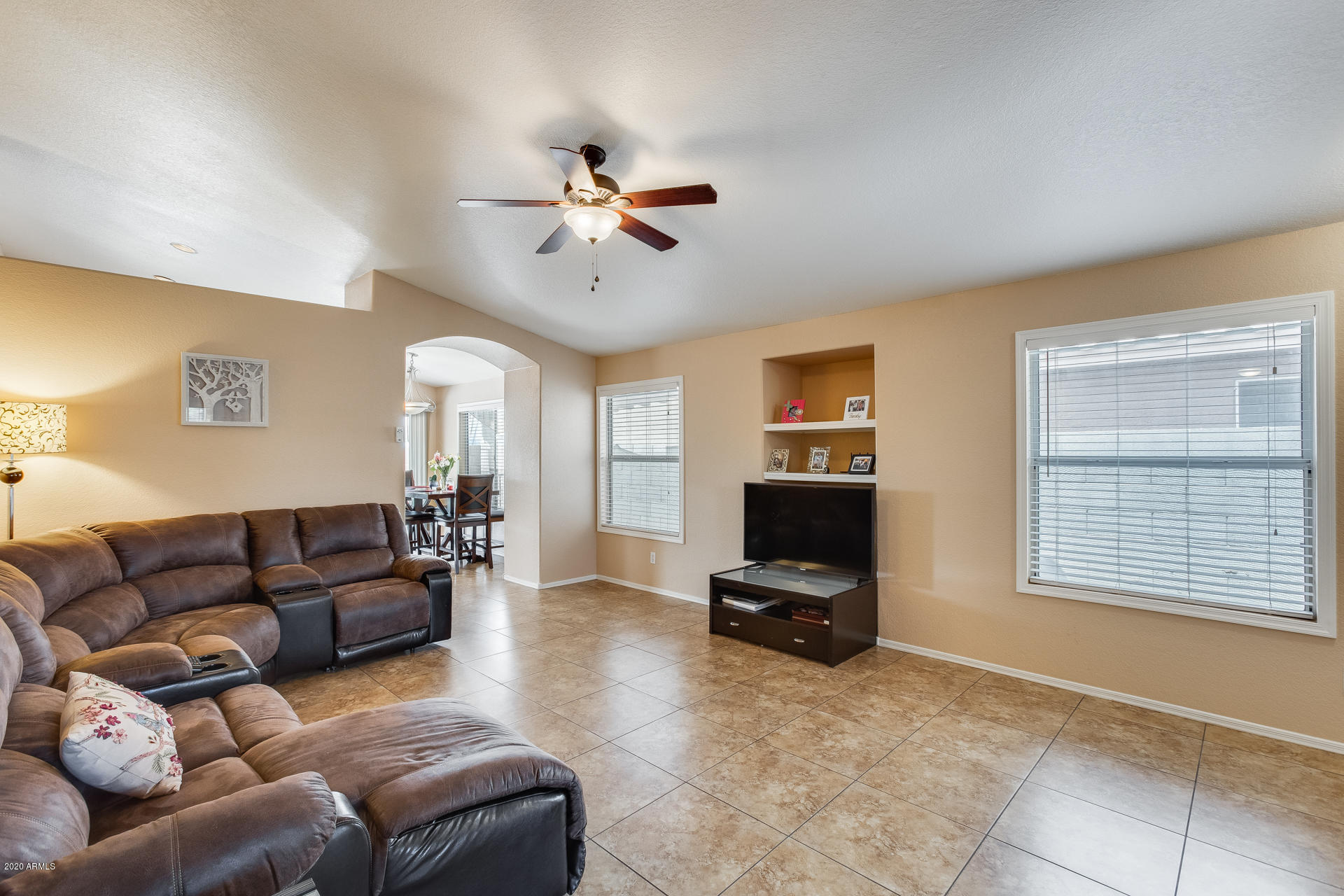 8713 West Coronado Road Phoenix, AZ 85037 - Photo 6 of 27 a living room with furniture ceiling fan and a window