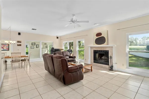 a living room with furniture a fireplace and a large window