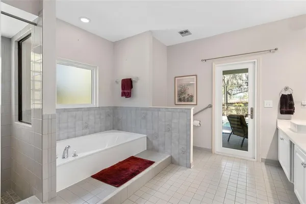 a bathroom with a tub shower and mirror