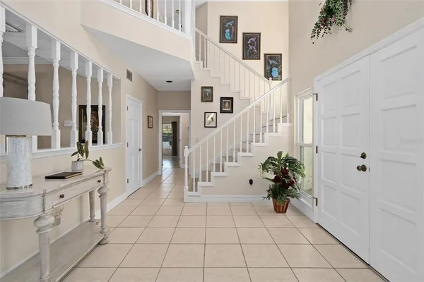 a hallway with white cabinets and chandelier