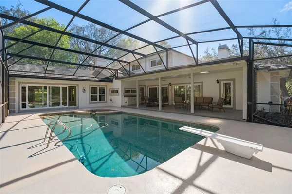 a view of a swimming pool with a patio and a yard