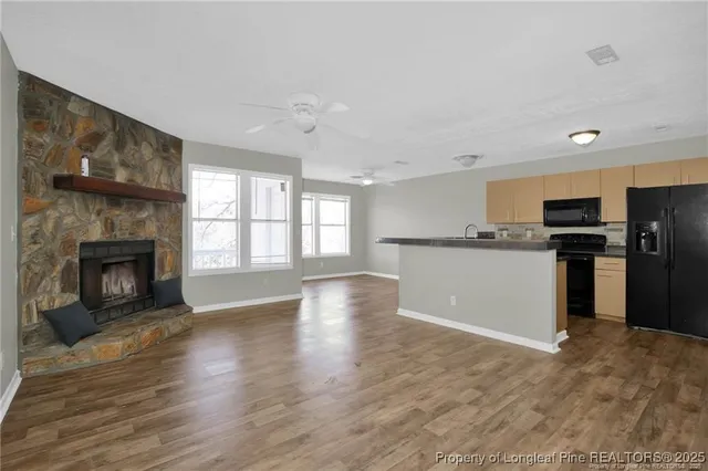a view of a kitchen with a stove wooden cabinets and entryway