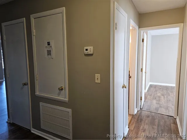 a view of a hallway with wooden floor and closet area