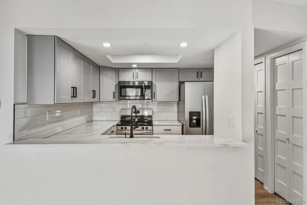 a kitchen with stainless steel appliances a refrigerator a sink a stove a microwave and cabinets