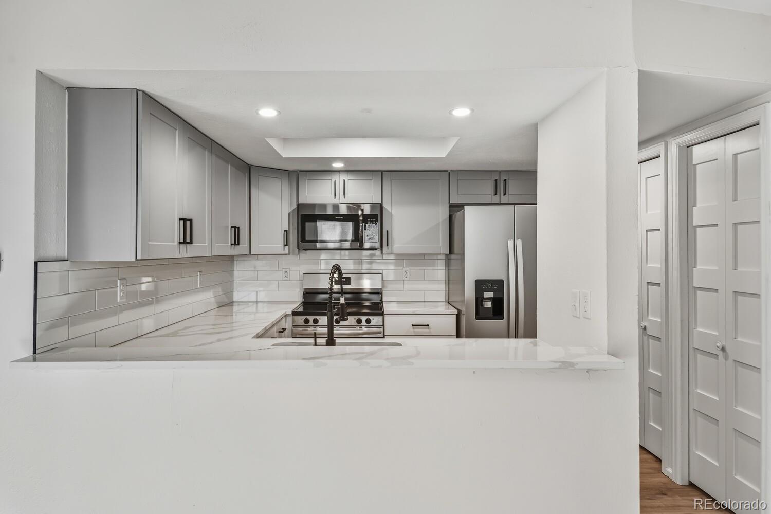 9041 Zephyr Court Broomfield, CO 80021 - Photo 13 of 35 a kitchen with stainless steel appliances a refrigerator a sink a stove a microwave and cabinets