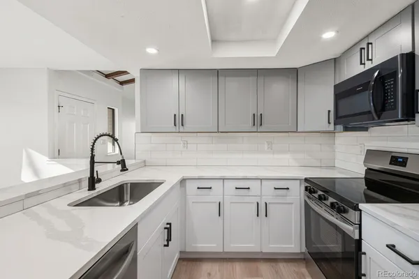 a kitchen with white cabinets stainless steel appliances and sink