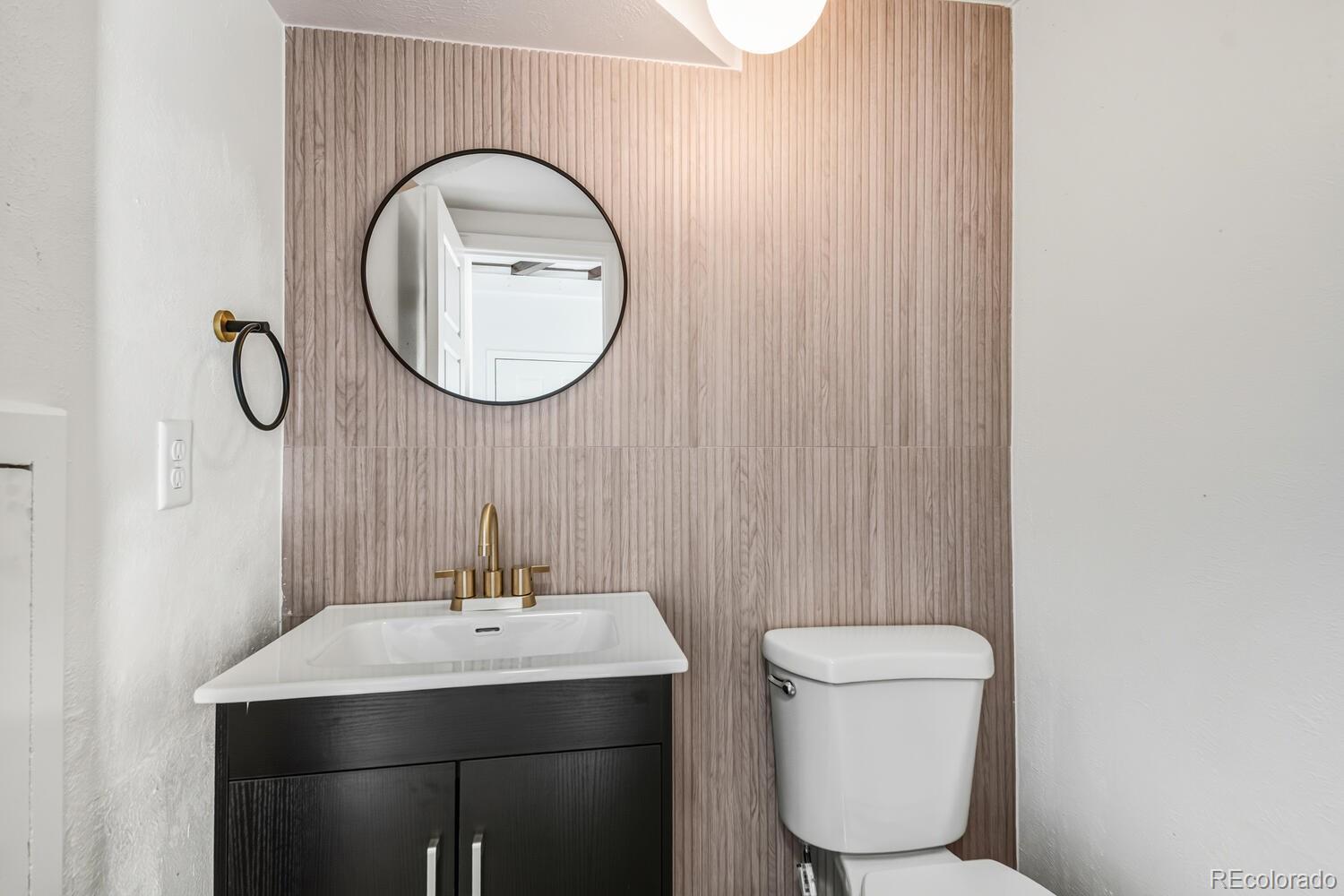 9041 Zephyr Court Broomfield, CO 80021 - Photo 21 of 35 a bathroom with a toilet a sink and a mirror