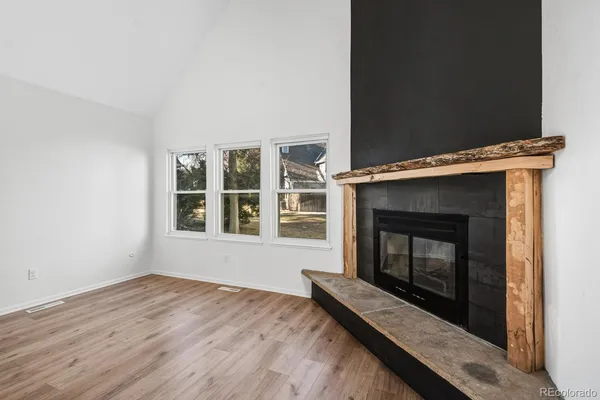a living room with a fireplace and a wooden floor