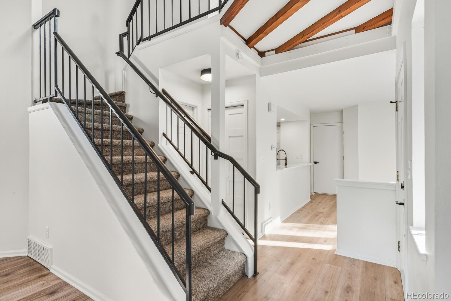 9041 Zephyr Court Broomfield, CO 80021 - Photo 8 of 35 a view of staircase with wooden floor and white walls