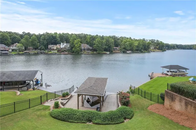 a view of a lake with couches and wooden fence