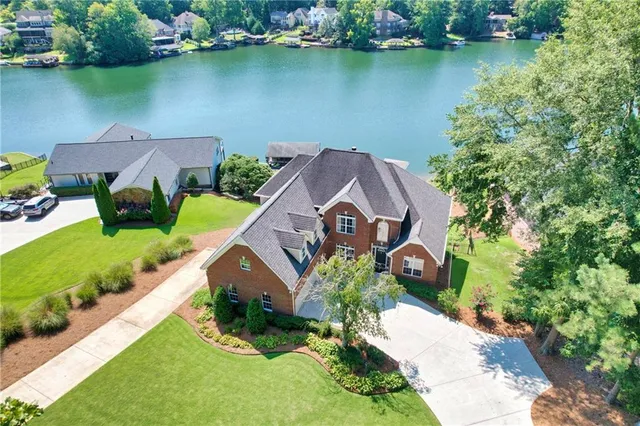 an aerial view of a house with a yard and lake view