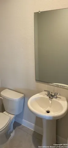 a bathroom with a toilet a sink and mirror