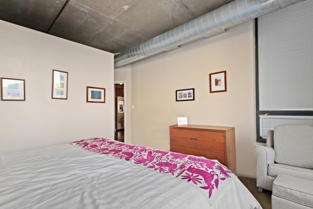520 South State Street, Unit 711 Chicago, IL 60605 - Photo 17 of 28 a bedroom with a bed and wooden floor