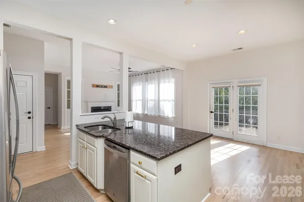 a kitchen with granite countertop a sink stainless steel appliances and cabinets