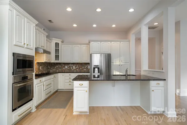 a kitchen with stainless steel appliances granite countertop a sink stove and refrigerator