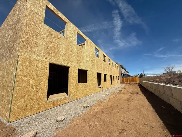 a living room with furniture kitchen view and a wooden floor