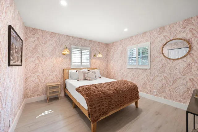 a bedroom with a bed lamp and a potted plant