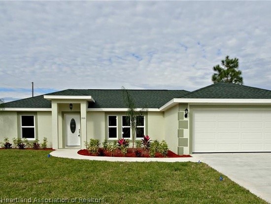 a front view of a house with a yard and garage